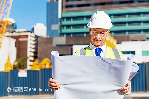 建筑工地的工程师建设者工程师建筑工人施工场景穿着带蓝图的安全背心